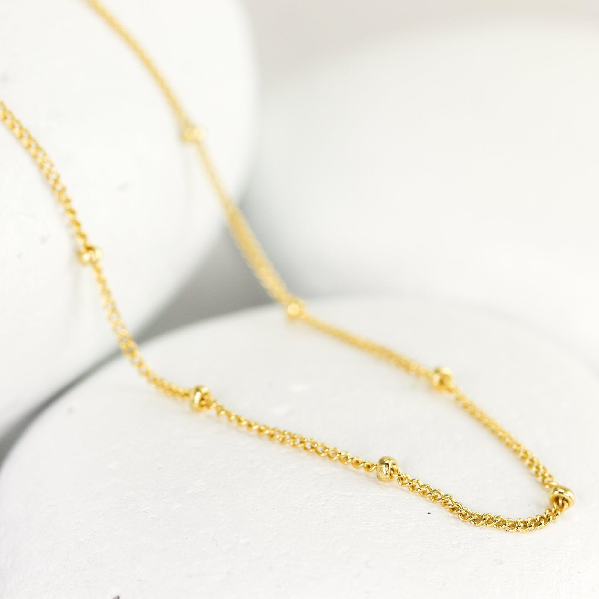 Long dainty beaded chain necklace featuring faceted bead details with star  accents. Approximately 32